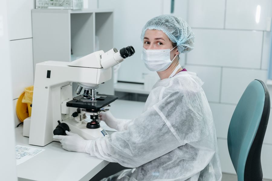 Laboratory scientist examining samples under a microscope